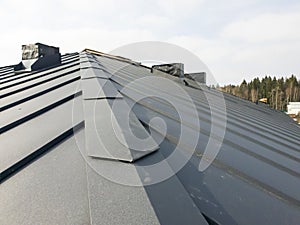 close up view of grey folding roof and chimney on waterproofing layer of house under construction