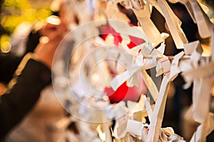 Close-up view Group of Omikuji, a fortune telling paper strip, tied on the ropes with blurred background