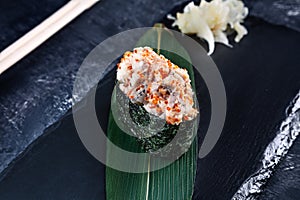 Close up view on gunkan sushi with spicy sauce and eel on dark stone background. Fresh Japanese cuisine. asian food. Sushi image