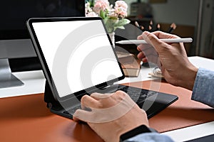 Hand of businessman holding stylus pen pointing on screen of computer tablet.