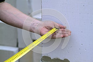 Close up view of the hand holding the measuring tape next to the