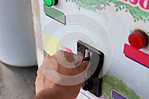 Close up view of hand of human inserting coin in to the old vending machine,Shallow depth of field, Automatic Machine