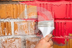 Close up view of hand with paint brush in red color