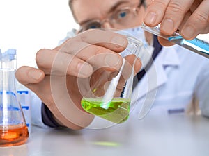 Close up view of a hands of male researcher carrying out scientific research in a lab.
