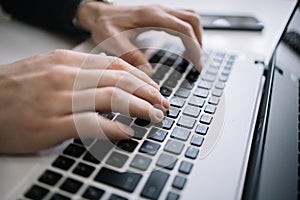 Close-up view of hands over laptop keyboard