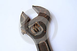Close-up view of the head of an old rusty adjustable wrench on white background. Old rusty iron wrench for turning screws