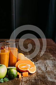 close-up view of healthy orange smoothie in glasses and fresh ingredients