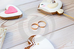 Close up view on heart shaped cookies bisquits on stick and wedding rings