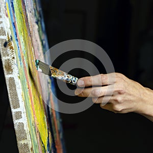 Close-up view of highly gifted painter while he is painting his picture