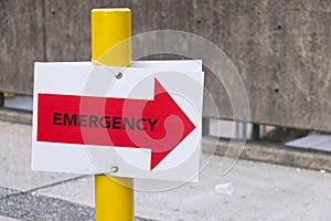 Close up view of Hospital emergency sign in red with directional arrow
