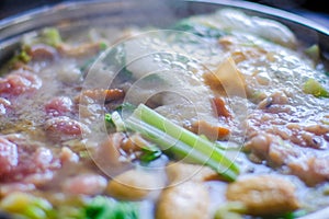 Close up view of hotpot with meat beef sliced and vegetables. Shabu Shabu is style beef in hotpot dish of thinly sliced meat