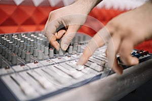 Close-up view of human hands tuning music mixer