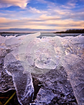 Close-up view of ice blocks breaking against water and land during frosty winter weather