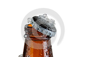 Close up view of an ice cold beer bottle neck and removed cap