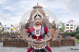 Close up View Indian classical Odissi dancer posing in front of Mukteshvara temple.