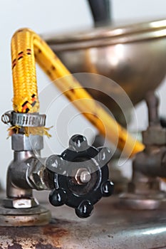 Close-up view of industrial black valve with yellow hose from the garment industry iron steam with blurry and soft focus