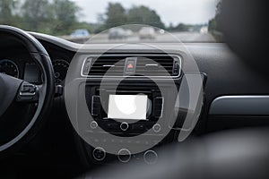 Close-up view inside car of dashboard with empty mockup on screen, and smartphone. GPS navigation system concept.