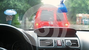 Close up view from inside of rain water drops falling on car windshield glass.