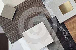 close up view of interior materials sample including black and gery marble stones, wooden vinyl flooring tiles, quartz, ceramic