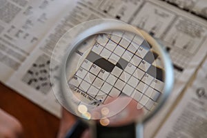 Close up view on international newspapers with a magnifying glass and a soft bokeh