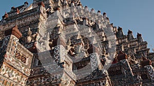 close-up view of the intricate architectural details of the Wat Arun temple in Bangkok, Thailand. The temple's prang