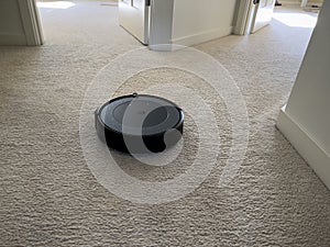 Seattle, WA USA - circa May 2023: Close up view of an iRobot Roomba on a light carpeted floor inside a family home