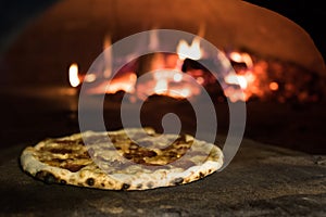 close up view of italian pizza baking in brick oven