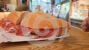 Close up view of a Jamon Serrano ham sandwich in a city food market restaurant, 4k