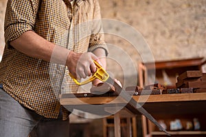 Close-up view of a joiner sawing wood