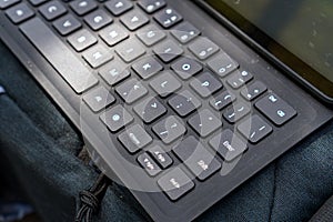 Close-up view of a keyboard for a tablet on a table, in an open room.