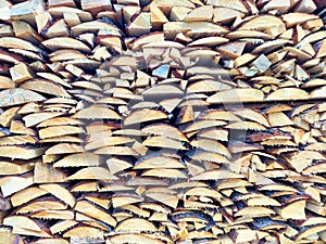 A close-up view of a large stack of split firewood logs, ready for the winter season. background, texture, pattern