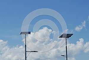 Close up view of LED street light with solar cell on clear blue sky background with clouds.