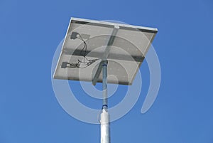 Close up view of LED street light with solar cell on clear blue sky background with clouds.