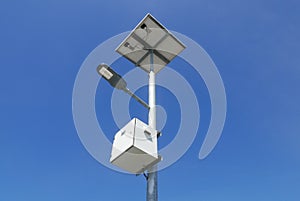 Close up view of LED street light with solar cell on clear blue sky background with clouds.