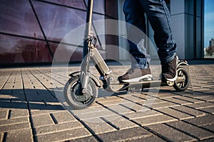 Close up view of legs of man on electric scooter