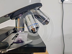 Close up view of a light microscope with glass slide focussed