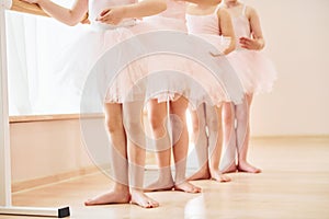 Close up view. Little ballerinas preparing for performance by practicing dance moves