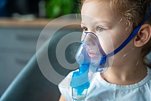 Close up view of little girl are sitting and holding a nebulizer mask leaning against the face, airway treatment concept