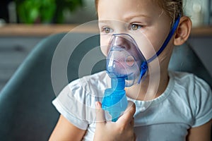 Close up view of little girl are sitting and holding a nebulizer mask leaning against the face, airway treatment concept