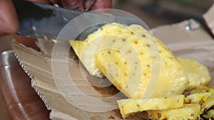 Close up view of a local man cutting pineapple, a very popular fruit which grows all around Sri Lanka.