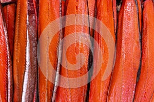 Close up view of lot fillet salted cold smoked red fish King Salmon. Prepared and ready-to-eat Pacific fish Chinook
