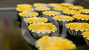 Close up view of making process egg tart in a mold on a black tray
