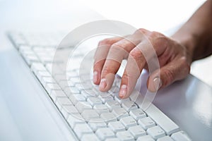 Close up view of a male hand typing on keyboard