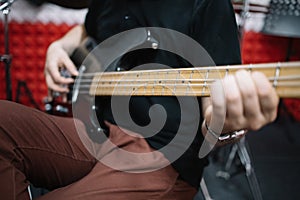 Close-up view of male hands playing electric guitar