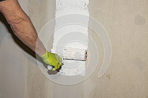 Close up view of male worker carrying out painting work.