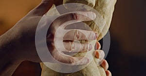 Close up view of males hands working on human torso from pottery clay. Sculptor creating sculpture in artist workshop