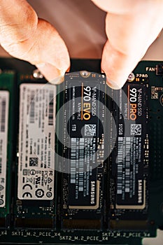 Close-up view of man hand inserting in the M2 connector the new Samsung NVME V