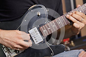 Close-up view of man playing electric guitar