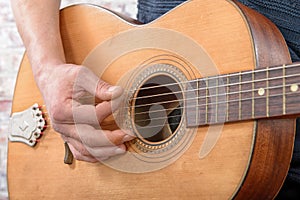 Close-up view of man`s hand playing guitar