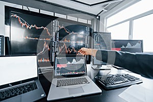 Close up view of man`s hand that points at part of stock graph on display